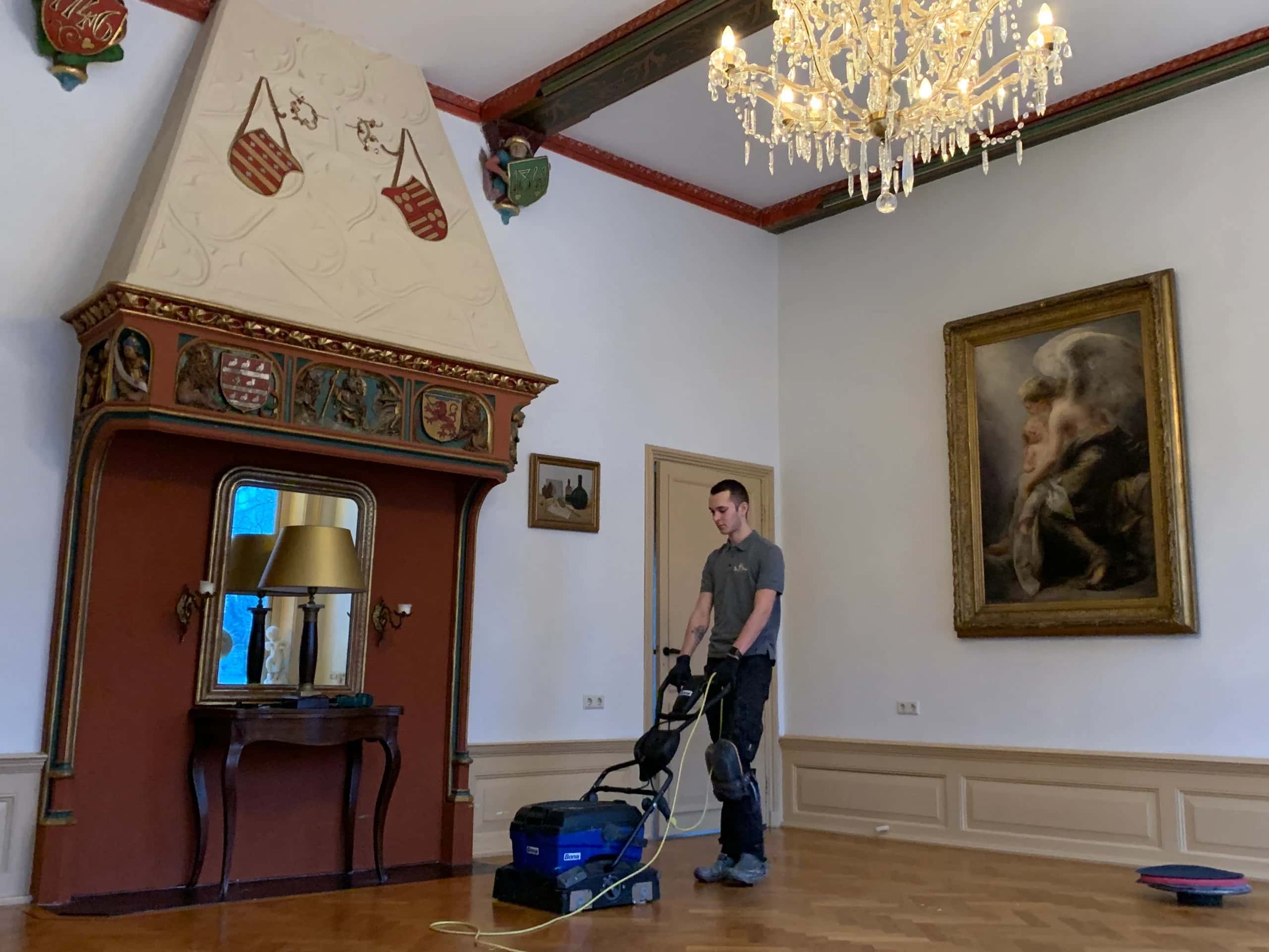 Vakman van Deley's Parket reinigt een visgraat parketvloer met het Bona Deep Clean-systeem in een monumentale zaal