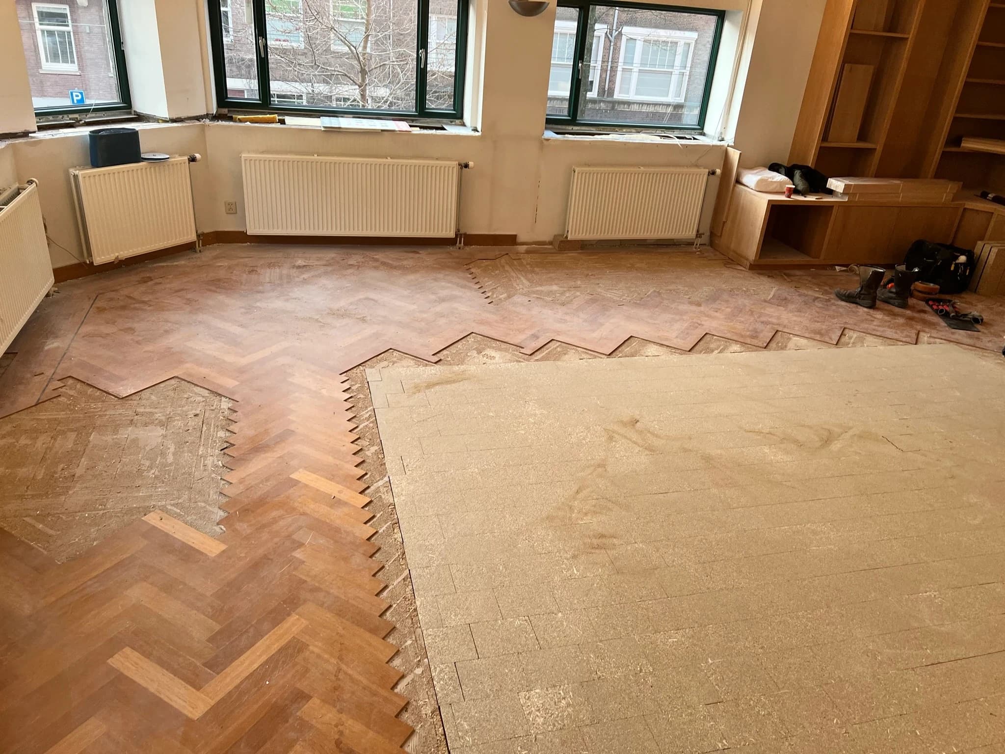 Eiken visgraat in Amsterdam vóór reparatie, deels nog onder oude vloerbedekking