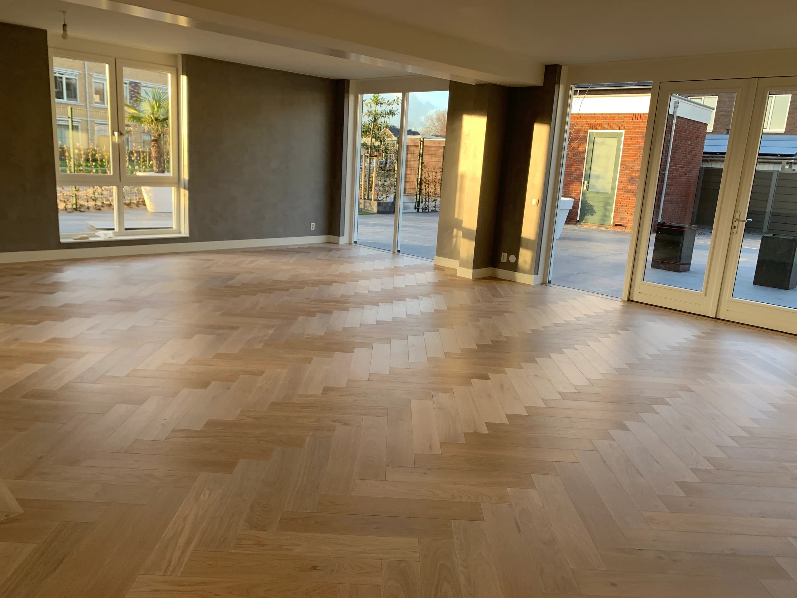 Open woonkamer met terrasdeuren en visgraat lamelparket in licht eiken, Vianen